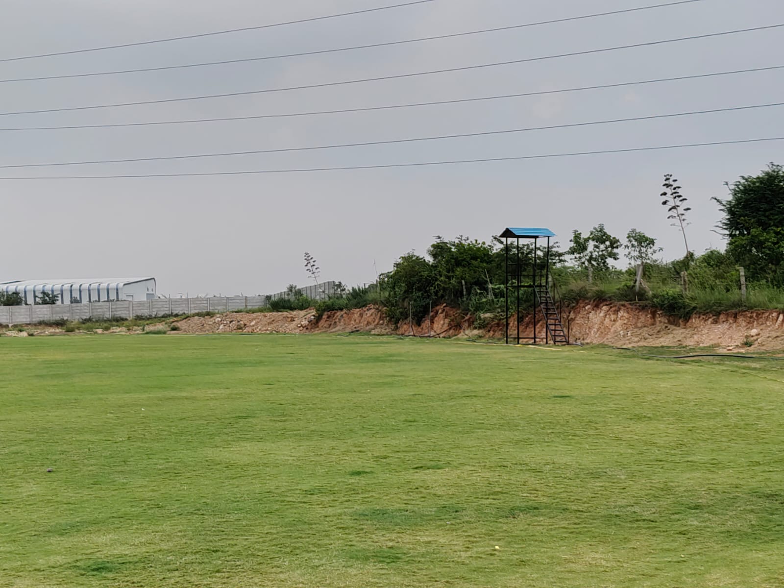 KSM cricket ground with an elevated camera-viewing platform beside the field