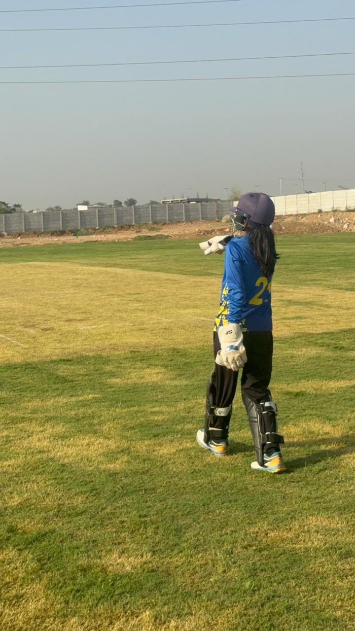 Academy batter walking across the cricket ground
